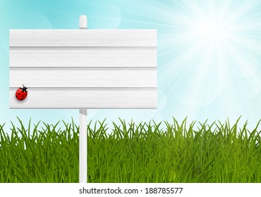Wooden signpost on green meadow