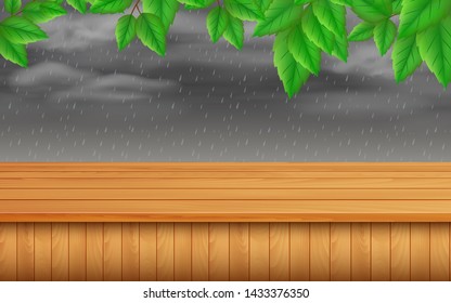 wooden table and green leafs on a rainy background