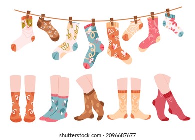 Woolen socks, foot underwear set vector illustration. Cartoon legs wear funny warm cotton socks with flowers and hearts, different stocking hanging on rope, collection of accessories isolated on white