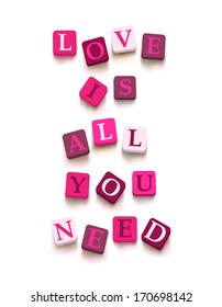 Words "love is all you need" with colorful blocks isolated on a white background. Description with bright cubes. Valentine's day card. Vector illustration EPS 10.