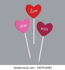 Words love, kiss, hoho on lollipops in the form of pink and red hearts close-up. Vector sweets, candies, isolated.