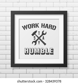 Work hard, stay humble - Quote typographical Background in realistic square black frame on the brick wall backgroundd . Vector EPS10 illustration. 