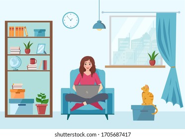 Work from home. Young woman sits on an armchair and works at a laptop in a cozy room