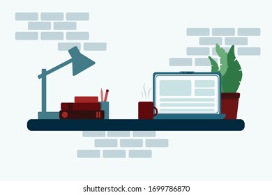 Work table with notebook, desk lamp, books, cup and plant. 