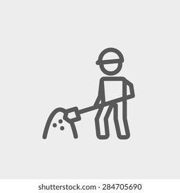 Worker with hard hat and shovel in building site icon thin line for web and mobile, modern minimalistic flat design. Vector dark grey icon on light grey background.