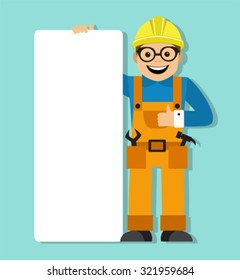 worker in helmet holding a blank poster. Work is dressed in overalls and his tools in his pockets.