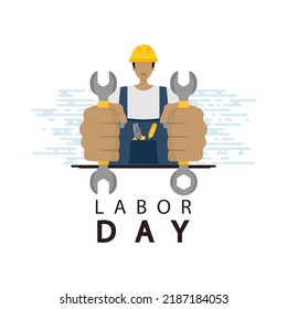 A worker in overalls and a construction helmet holds tools in his hands. Labor Day.