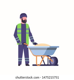 worker in uniform pushing wheelbarrow with sand winter snow removal concept man working outdoor flat full length