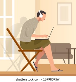 Trabajar desde casa sentado en la silla mientras mira la pantalla del portátil y escucha los auriculares