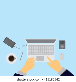 Workplace concept. Top view laptop, notebook, pencil, mobile phone, hands,blue background