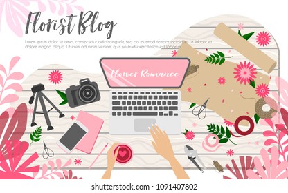 Workplace of floral blogger, view from above, desktop, laptop, phone, wrapping paper, flowers and arms on the white wooden table