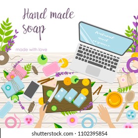 Workplace of handmade cosmetics and soap making master, view from above, desktop, oil, bath bombs, laptop, and arms