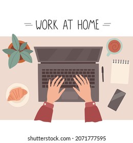 Workplace at home, top view. Hands on the keyboard, cup of coffee, notepad, phone, croissant and potted houseplant.