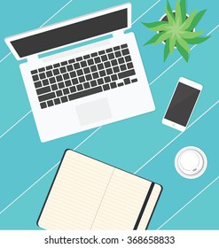Workplace, Office supplies on the  table - laptop, sketchbook, smartphone, flower and a plastic glass of coffee 