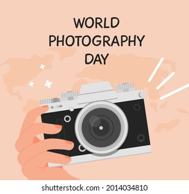 World photography day greeting card. Square banner with a hand holding digital camera in retro look. Background with world map. Vector illustration in flat cartoon style.