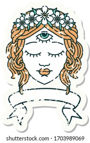 worn old sticker with banner of female face with third eye and crown of flowers