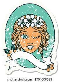 worn old sticker with banner of a maiden with crown of flowers winking