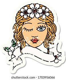 worn old sticker with banner of a maidens face winking