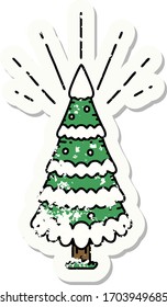 worn old sticker of a tattoo style snow covered pine tree