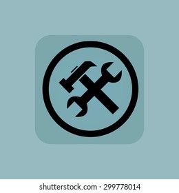 Wrench and hammer in circle, in square, on pale blue background