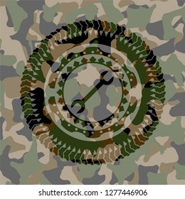 wrench icon inside camouflaged emblem