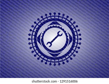 wrench icon inside emblem with jean background