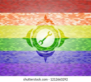 wrench icon inside emblem on mosaic background with the colors of the LGBT flag