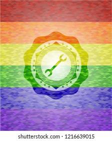 wrench icon inside emblem on mosaic background with the colors of the LGBT flag