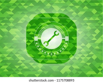wrench icon inside green emblem. Mosaic background