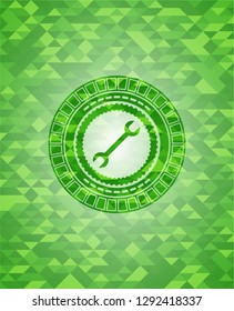 wrench icon inside green emblem. Mosaic background