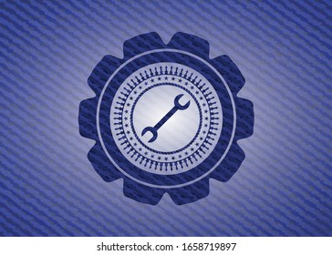 wrench icon inside jean or denim emblem or badge background
