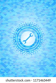 wrench icon inside light blue emblem with triangle mosaic background
