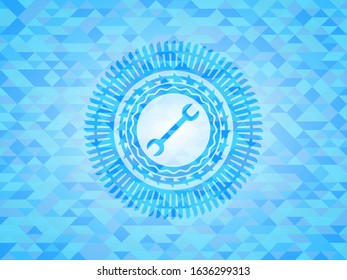 wrench icon inside light blue emblem with mosaic background