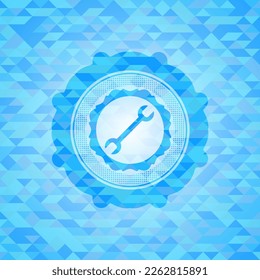 wrench icon inside light blue emblem with mosaic background. 