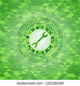wrench icon inside realistic green mosaic emblem