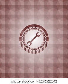 wrench icon inside red seamless badge with geometric background.