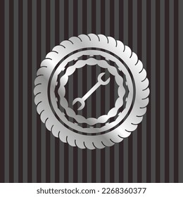 wrench icon inside silvery emblem. 