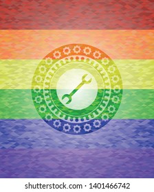 wrench icon on mosaic background with the colors of the LGBT flag