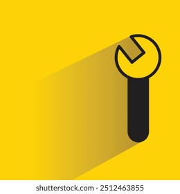 Icono de herramienta de llave inglesa con sombra sobre fondo amarillo