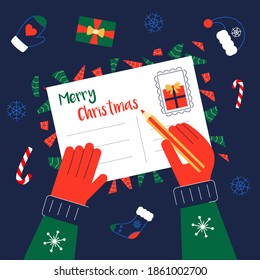 Write Christmas greeting cards for family and friends. Hands with pencil on Xmas postcard. Winter holidays wishes. Top view on the table.