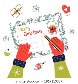 Write chritmas greeting card for family and friends. Hands with pencil on xmas postcard. Winter holidays wishes. Top view on the table.