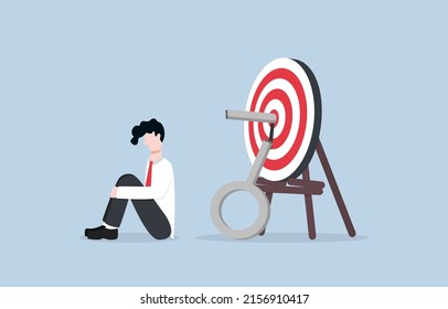Wrong solution cause business failure, fail to achieve goal, disappointment from unsuccessful project concept. Businessman sadly sitting on floor after he could not unlock key on archery target.