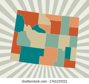 Wyoming map. Poster with map of the US state in retro color palette. Shape of Wyoming with sunburst rays background. Vector illustration.