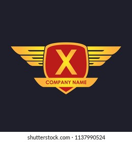 X initial shield with wings gold color logo