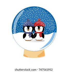 Xmas and New Year present. Snowglobe with two winter penguins in red and blue hats inside.