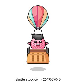 yarn ball mascot riding a hot air balloon , cute design