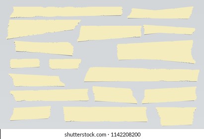 Yellow adhesive, sticky, masking, duct tape, paper strips pieces for text on gray background.