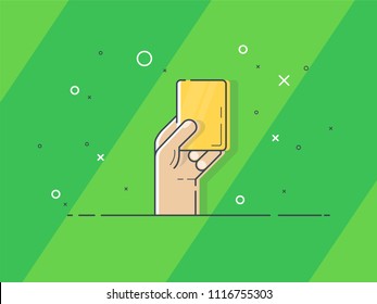 Yellow card in hand. Referee hand holding yellow card. Trendy flat vector on green background.