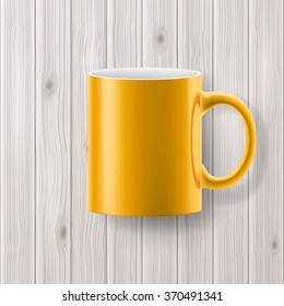 Yellow cup or mug isolated on wooden backdrop