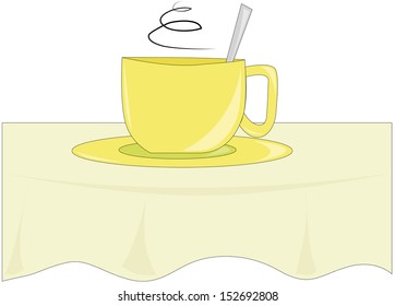 yellow cup on the table with a green tablecloth